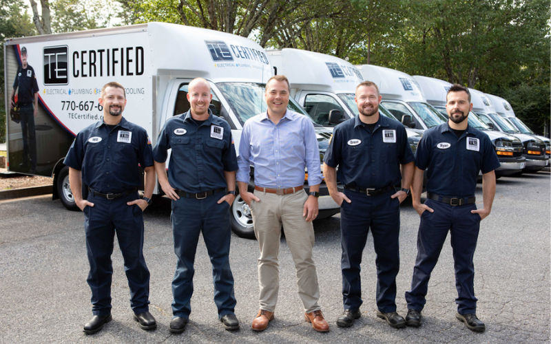 The team at TE Electric standing in front of trucks