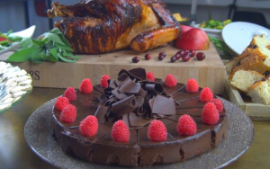 A chocolate cake with a turkey in the background