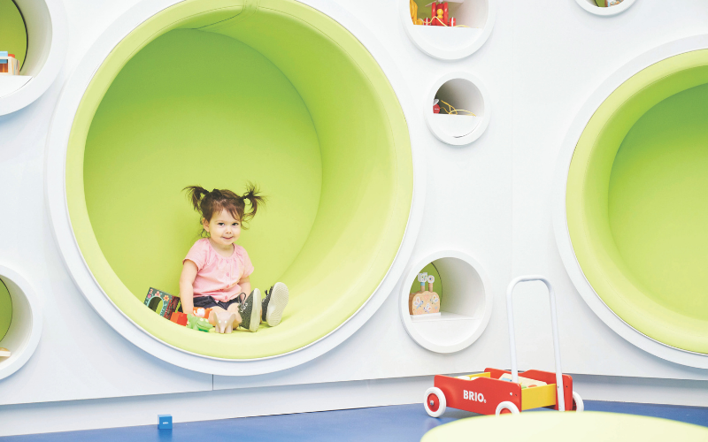 Little girl sitting in a play area