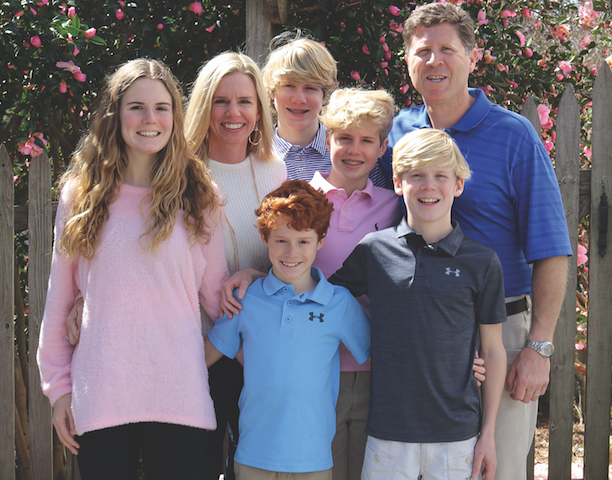 The Neumann Family dressed in pink in front of flowers