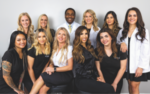 The Timeless Aesthetics team in front of a white wall wearing black scrubs