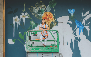 A girl in front of a mural