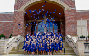 high schoolers throwing graduation caps in the air