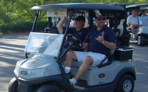 2 men on a gold cart