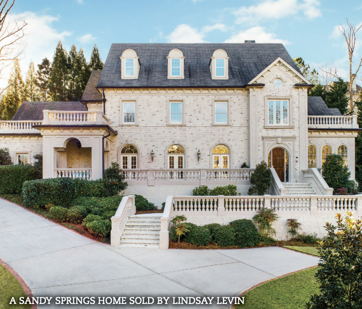 A large 3 story home with white exterior
