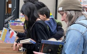 People looking through boxes of books