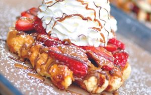 House waffle with strawberries and whip cream
