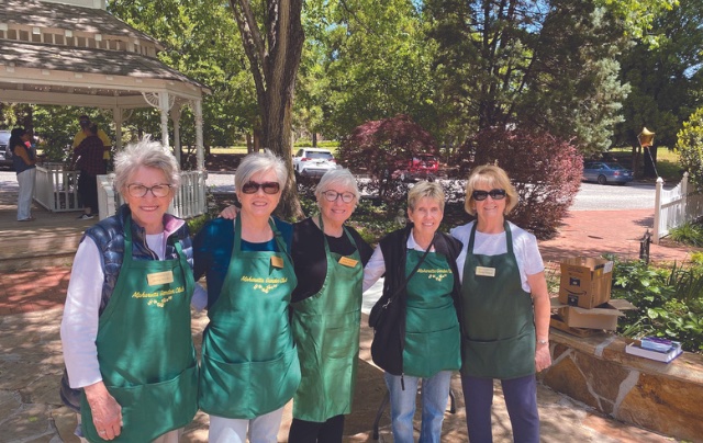 Women in green aprons outside