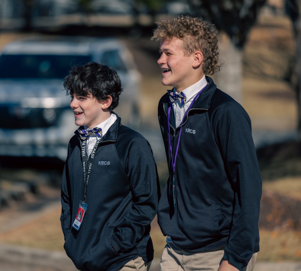 Two boys laughing in school uniforms