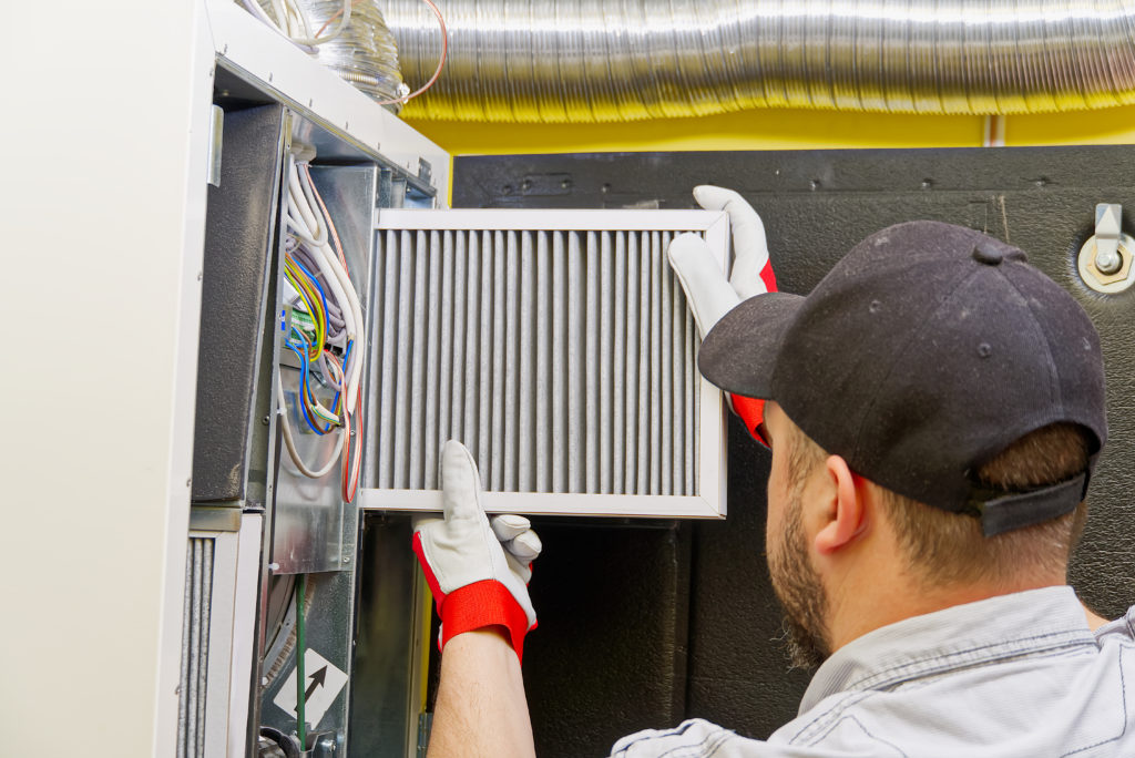 HVAC service technician changing dirty air filter