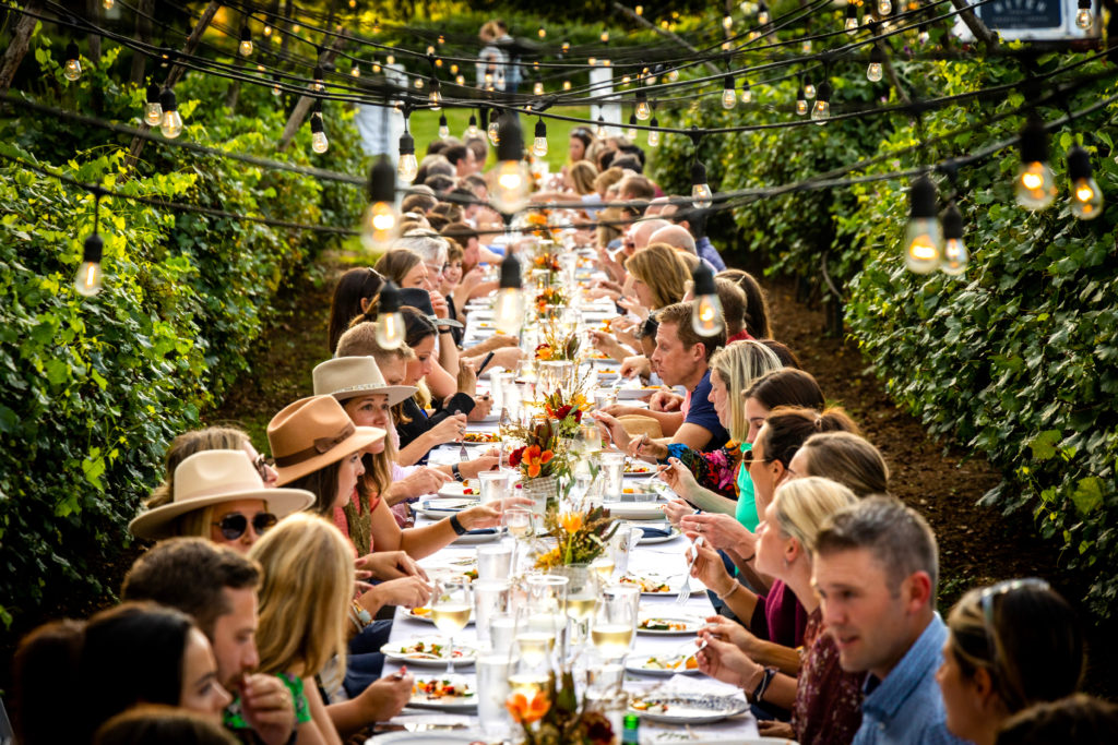 People eating at long table outside